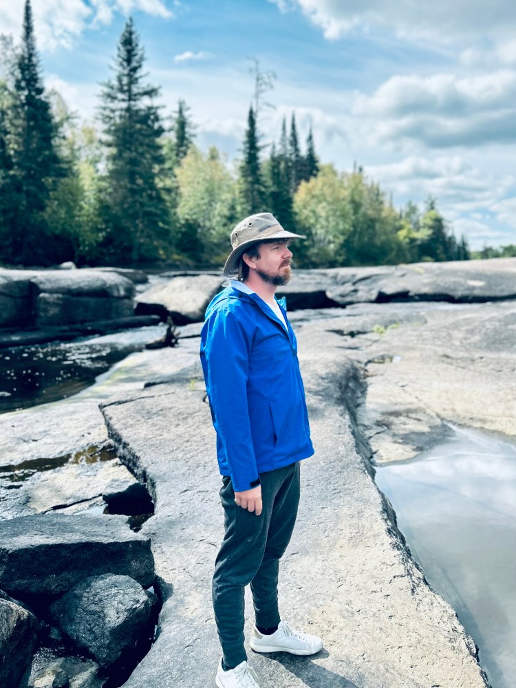 A man standing on rocks in the forest
