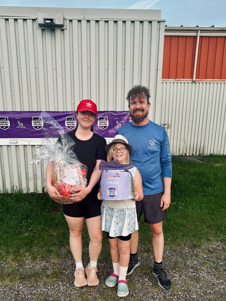 a man, a woman, and a girl holding a trophy