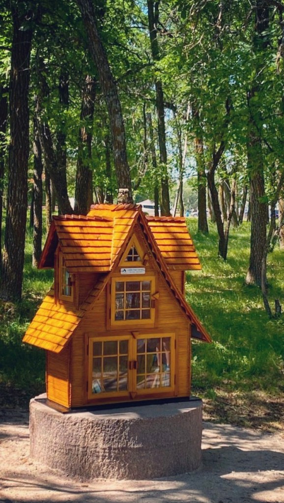 A wooden lending library in a park
