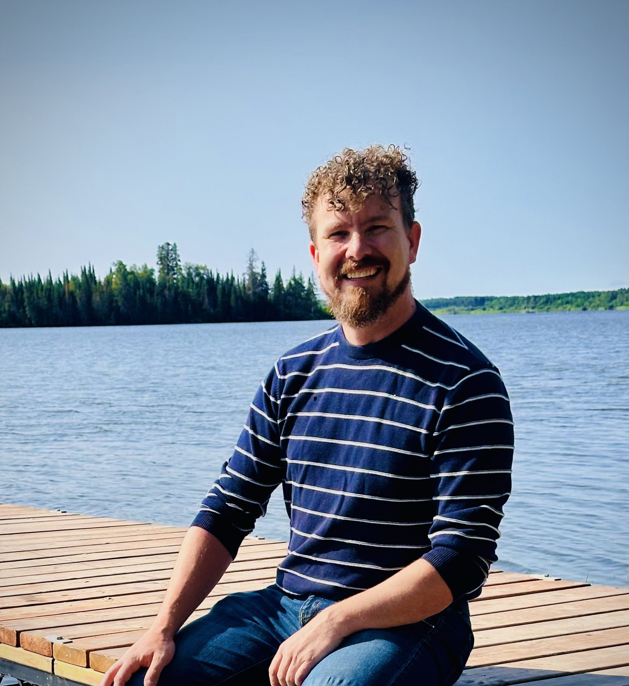 A man sitting on a dock smiling