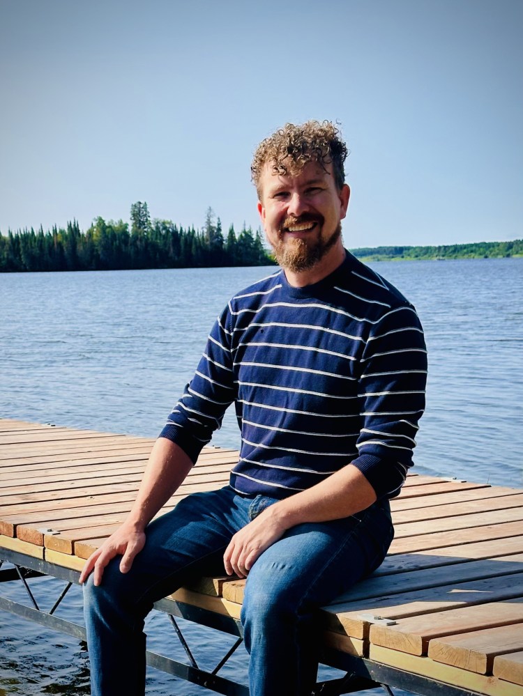 A man sitting on a dock smiling