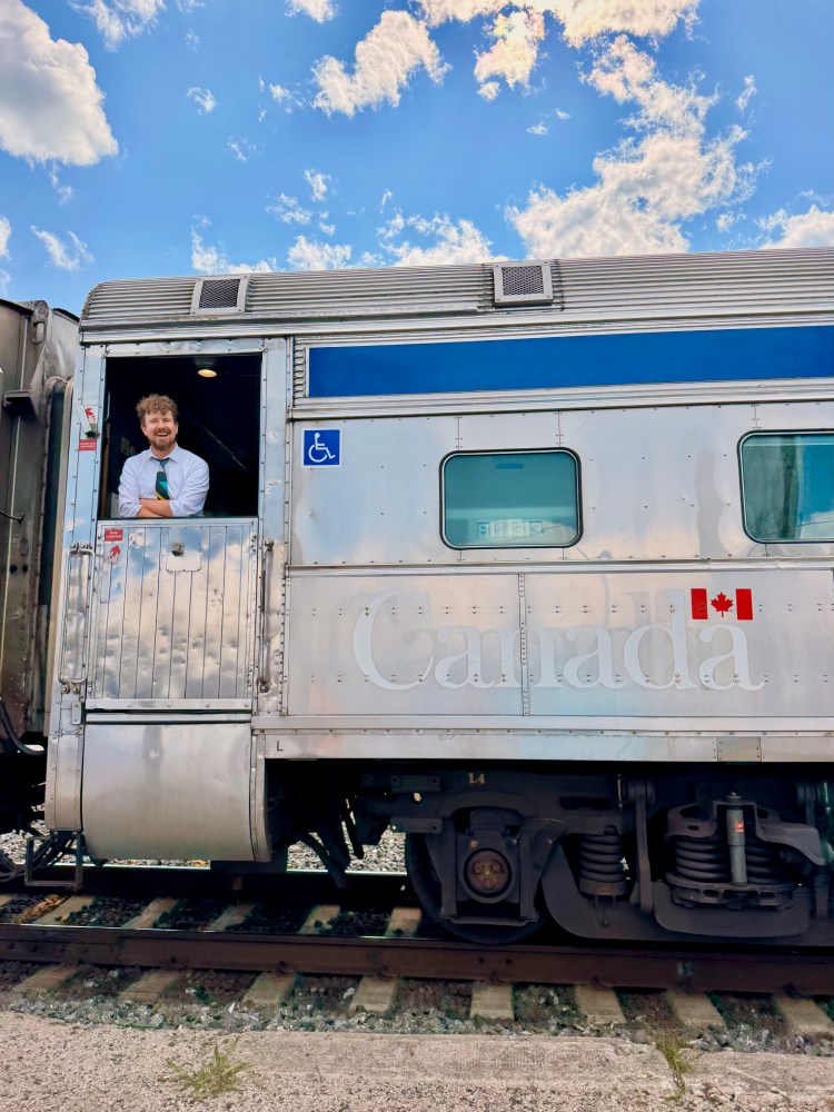 a man on a passenger train with a blue sky in Canada